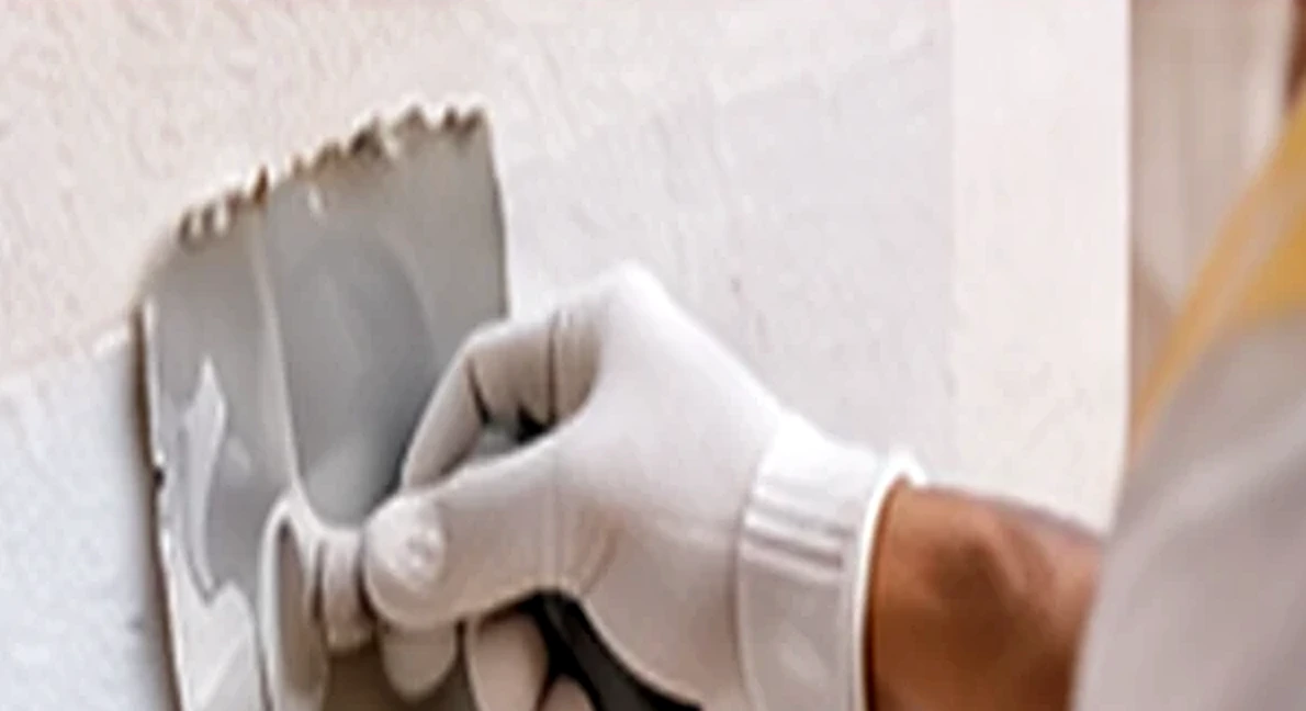 Profesional reparando una pared con herramientas